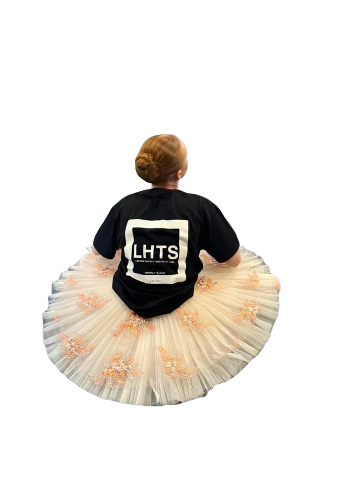LHTS dancer sitting in a tutu, showing the LHTS logo on the back of her black T-shirt